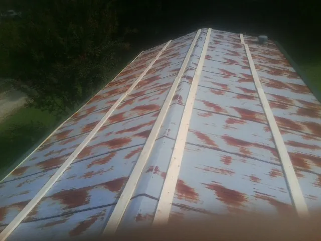 Rusted metal roof panels with new wood purlins before replacement — Storm Damage Roof Repair in Panacea by Roofing Brothers