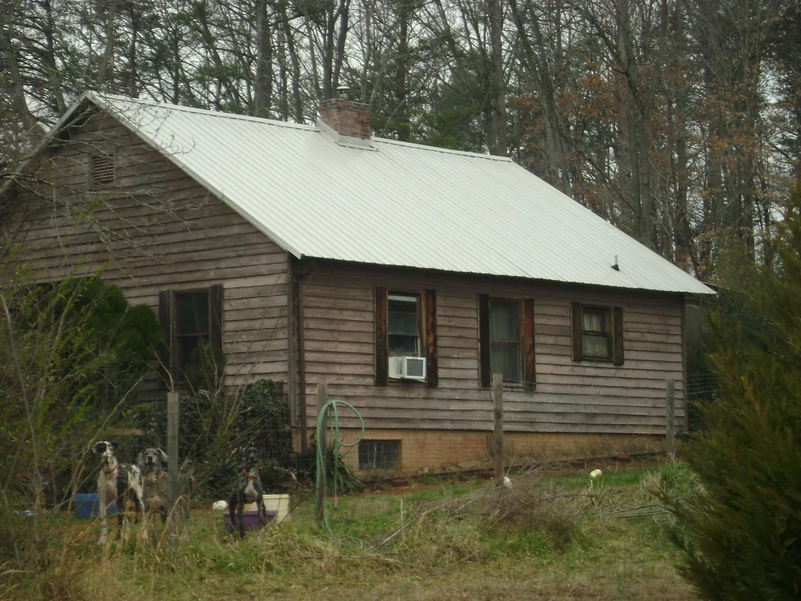 White metal roof on an old wood sided farmhouse, from a Metal Roof Installation job in Panacea